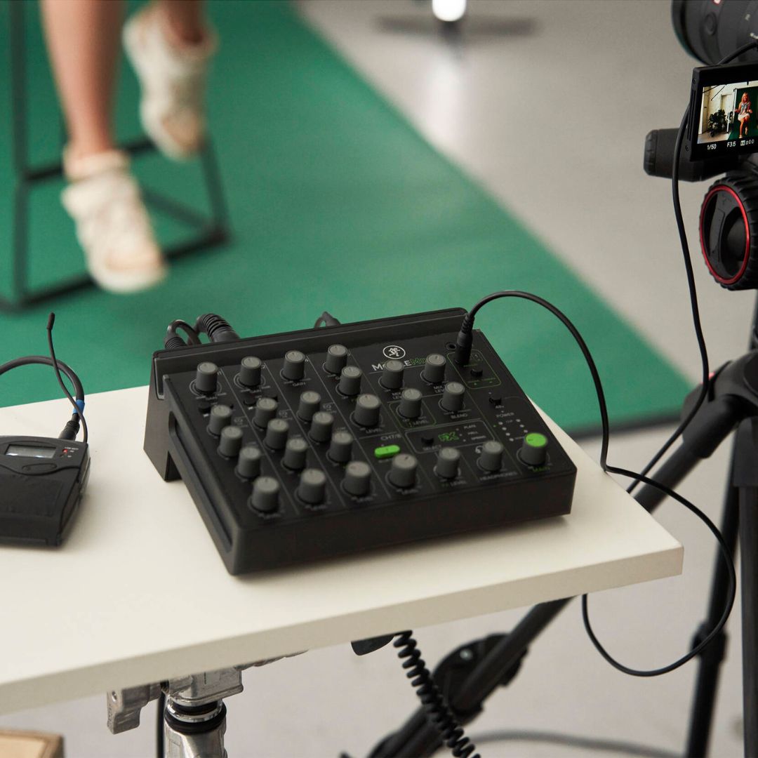 Black audio control surface on a white table with blurred background