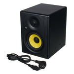Black studio monitor speaker with yellow cone and power cable on a white background
