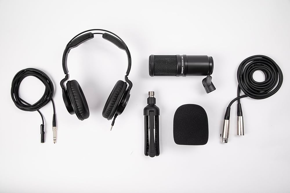 Collection of audio equipment including headphones, microphone, and cables on a white background