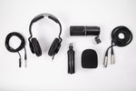 Collection of audio equipment including headphones, microphone, and cables on a white background