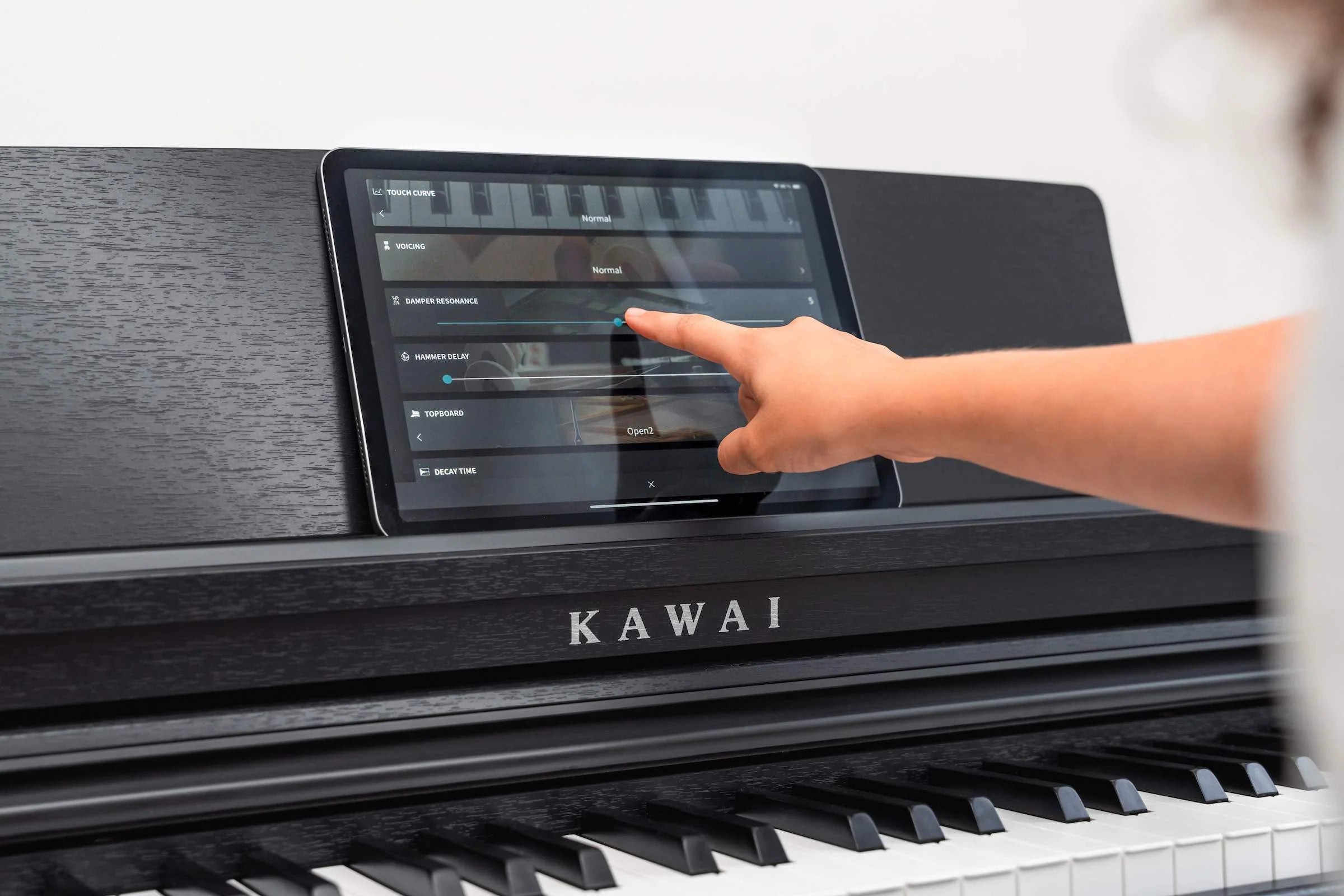 Person interacting with a Kawai digital piano's touch screen