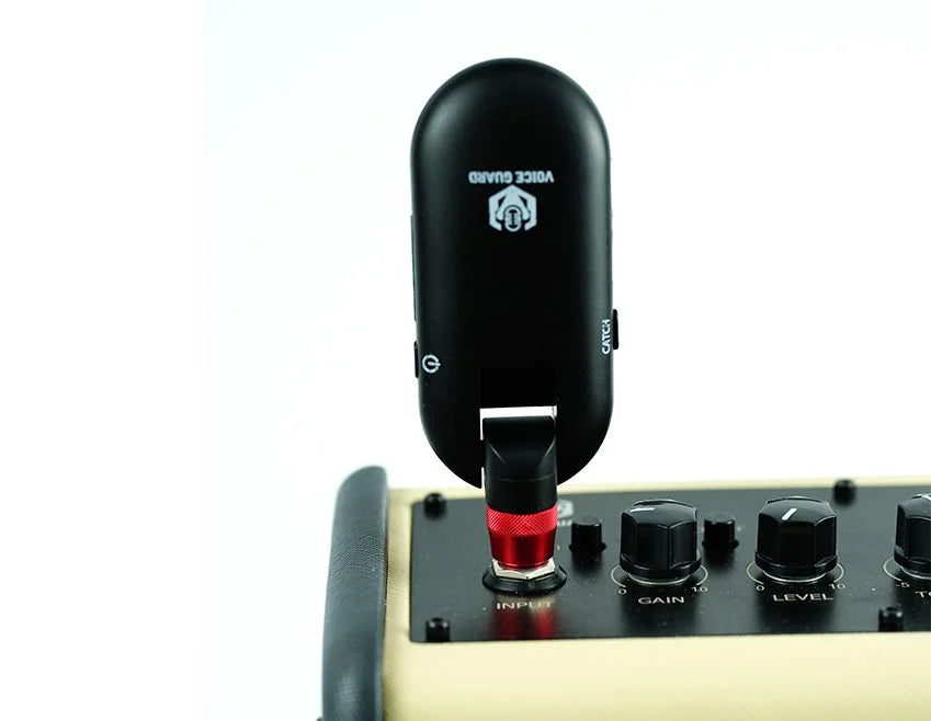 Black clip-on guitar pickup attached to a guitar amplifier with visible brand logo.