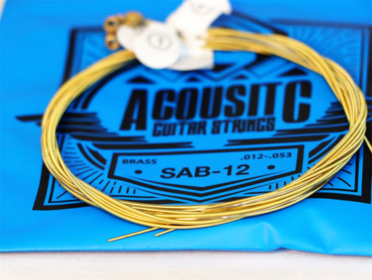 Acoustic guitar strings with packaging labeled 'Acoustic Guitar Strings' on a blue background.