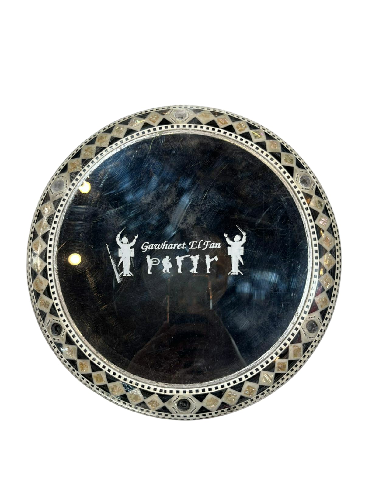 Decorative round object with intricate design and 'Gawharet El Fan' branding on a white background