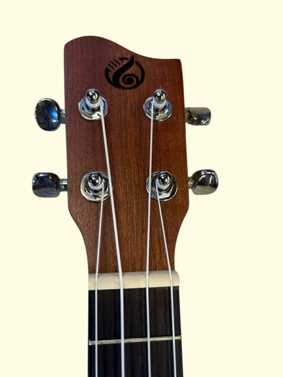 Close-up of a guitar headstock with tuning pegs on a white background