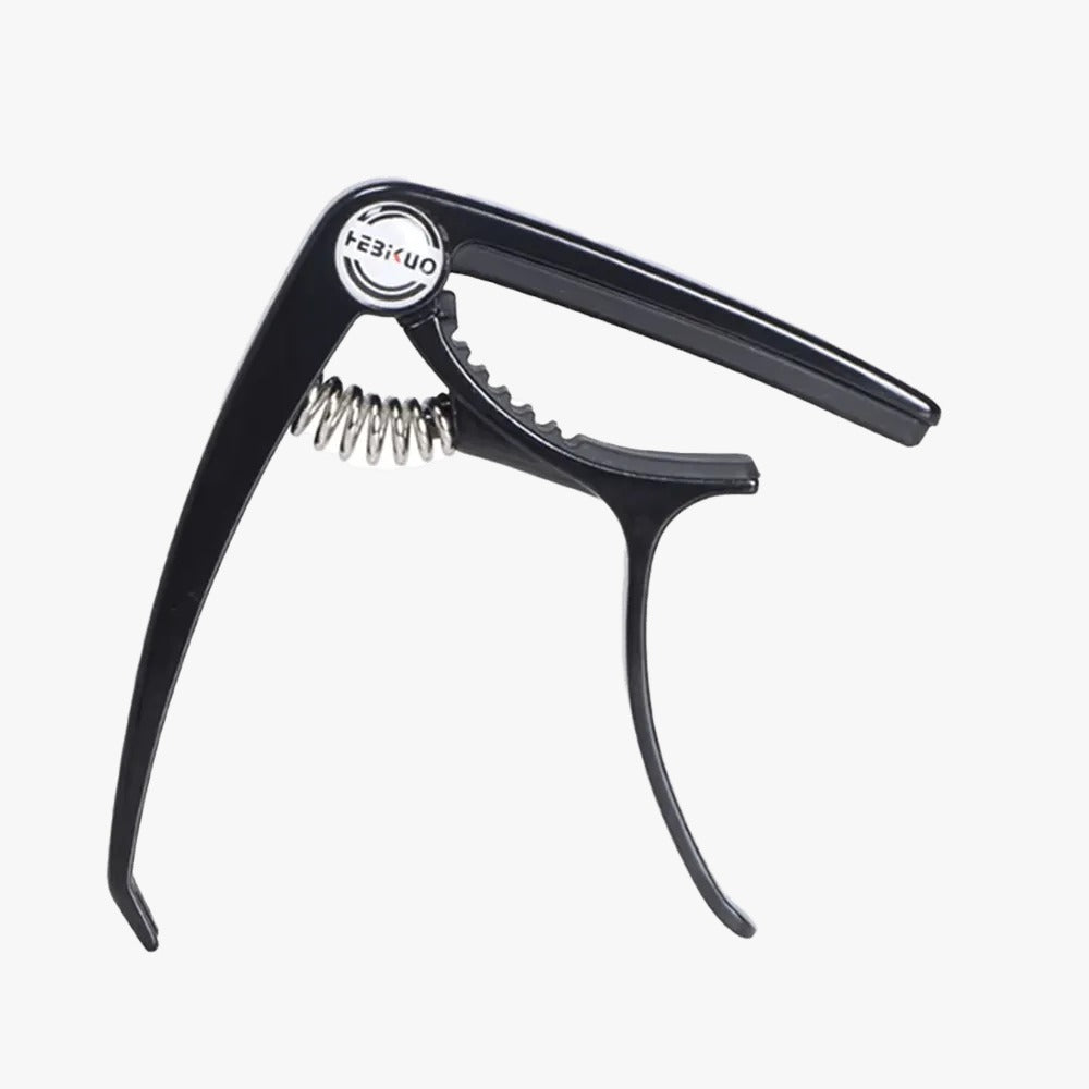 Black guitar capo on a white background