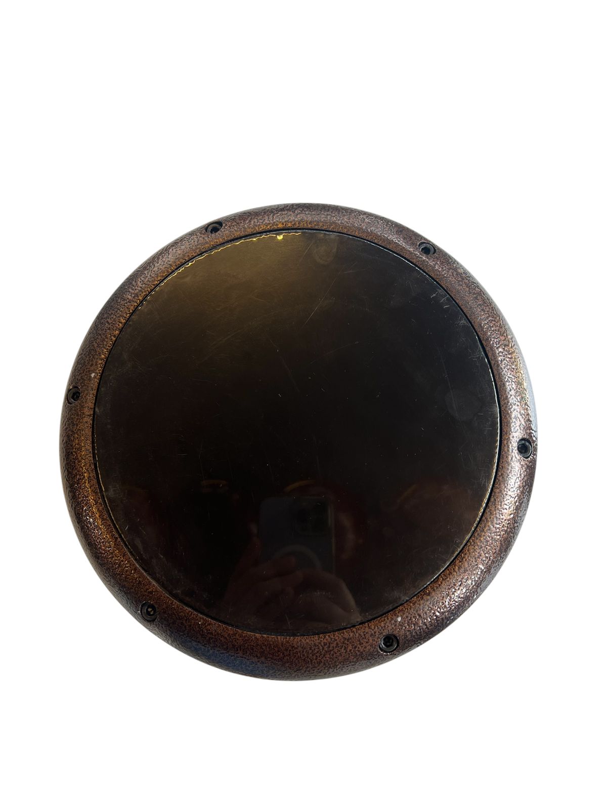 Round metallic object with a reflective surface on a white background
