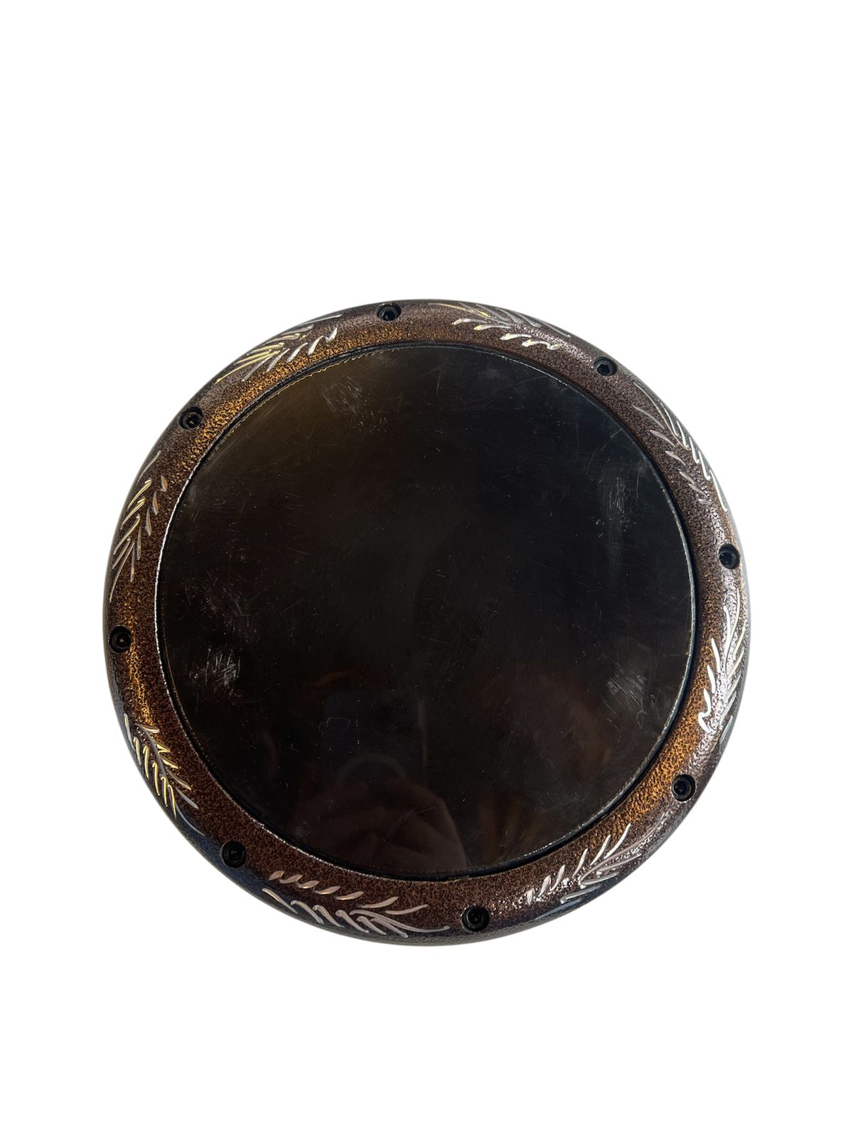 Round wooden object with decorative carvings on a white background