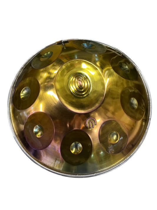 A brass steel pan drum, also known as a hang drum, photographed from directly above against a plain white background.