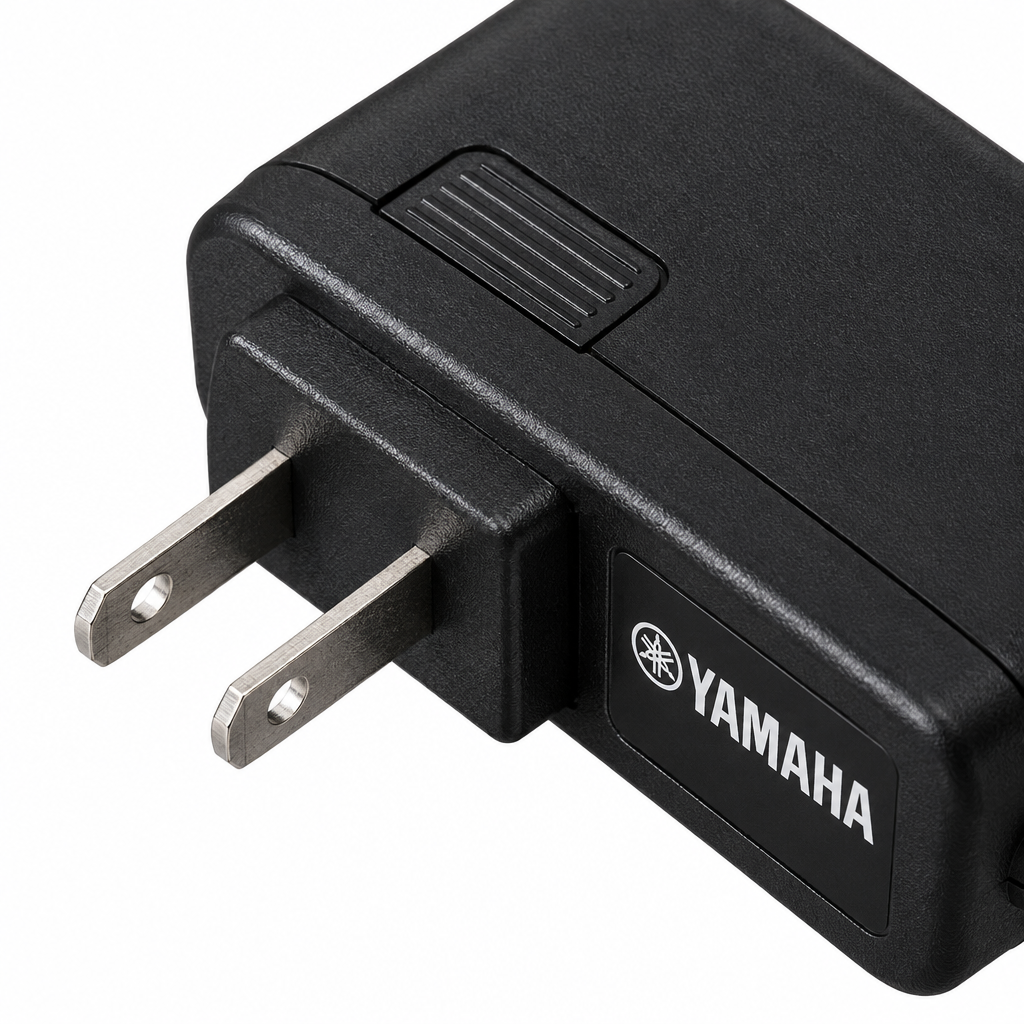 Close-up of the Yamaha PA-130 adapter housing and plug prongs.