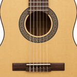 Straight-on close-up of the soundhole, rosette, nylon strings, and bridge on the Flight C100NA classical guitar.