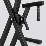 Close detail of the unbranded Q-2XC-1 black double-X keyboard stand central locking mechanism, adjustment handle, support arm, and rubber foot
