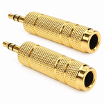 Two identical gold cylindrical jack converter pieces shown in a diagonal arrangement with knurled barrels, black insulating rings, male plug tips, and female socket openings