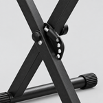 Close detail of the unbranded Q-2XB-1 black double-X keyboard stand central locking mechanism, adjustment handle, support arm, and rubber foot