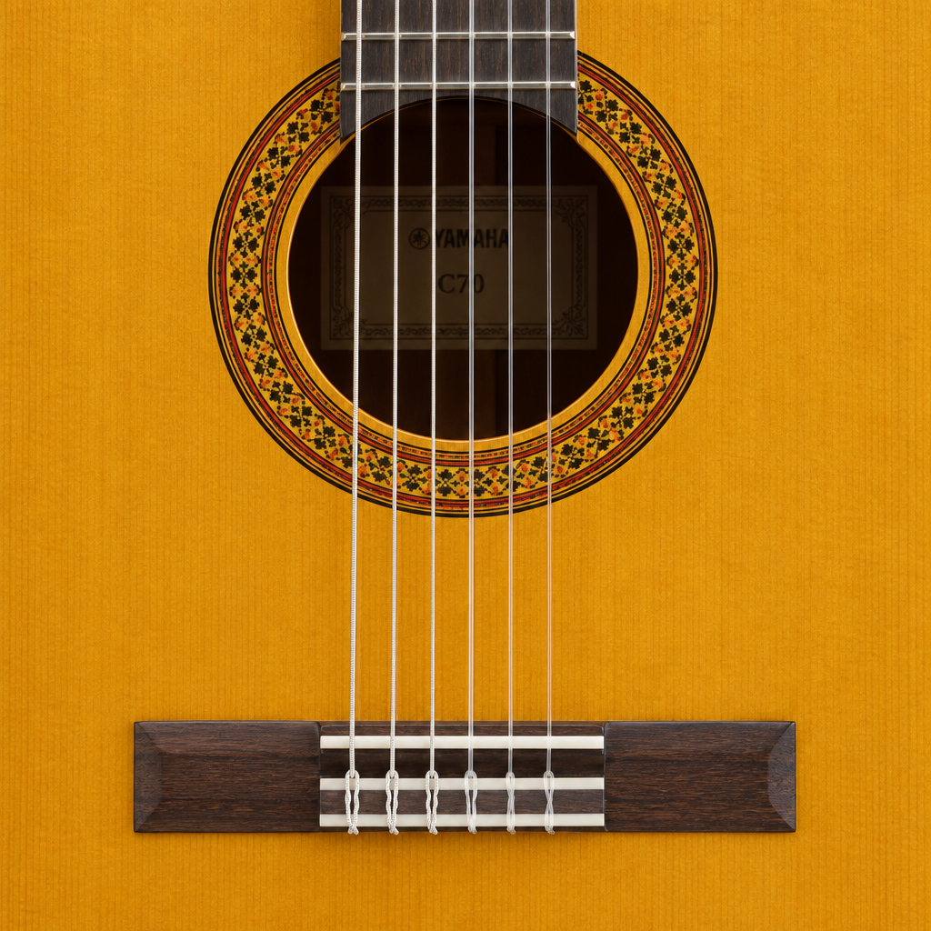 Straight-on close-up of the Yamaha C70 guitar's soundhole, rosette, nylon strings, and bridge.