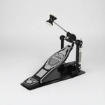 One Cymbal G610 black single drum pedal shown in a three-quarter diagonal view with its pedal board, beater, spring, frame, and hardware