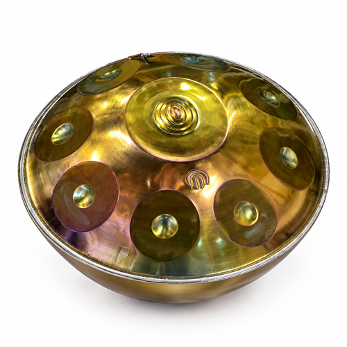 Egyptian-inspired metal handpan drum at an angled view showing the rounded shell, central dome, and tone fields