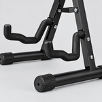 Close detail of the unbranded J-40B guitar stand padded contact arms, folding joint, frame, and ribbed rubber foot