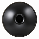 Underside of a black steel handpan showing the center sound opening and braided edge