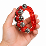 Red translucent handheld sleigh bell held in one adult hand